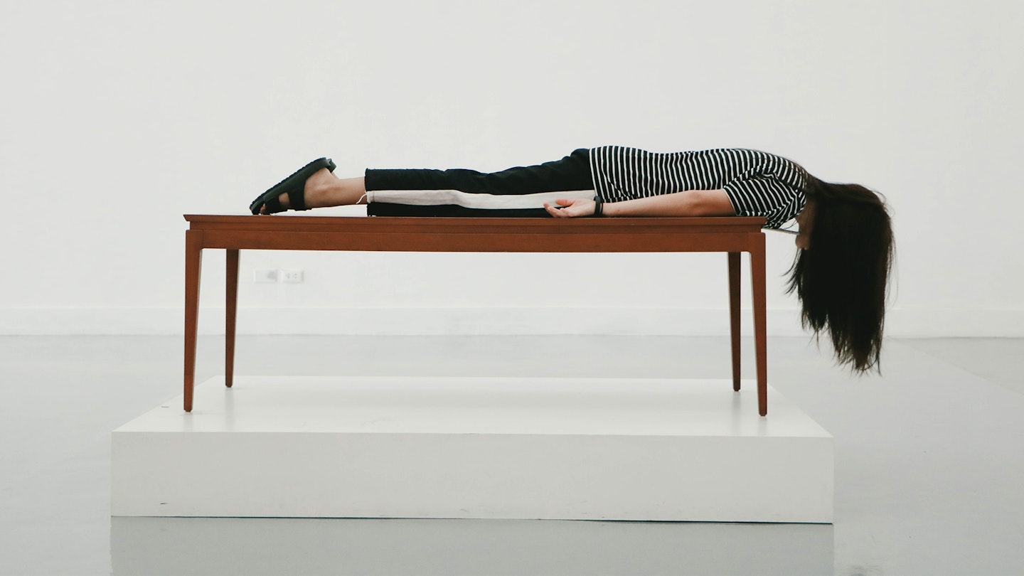 Photo of a woman sleeping on a bench in a museum - the best sleep gadgets