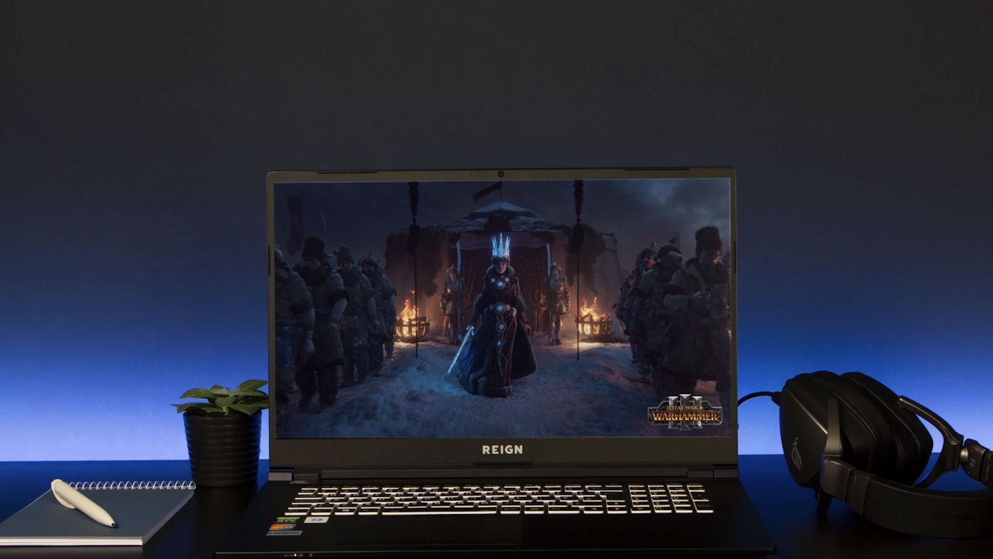 A Reign gaming laptop on a black desk 