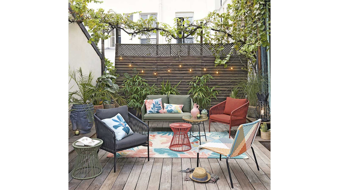 Patio with decking and fairy lights with tropical theme furniture