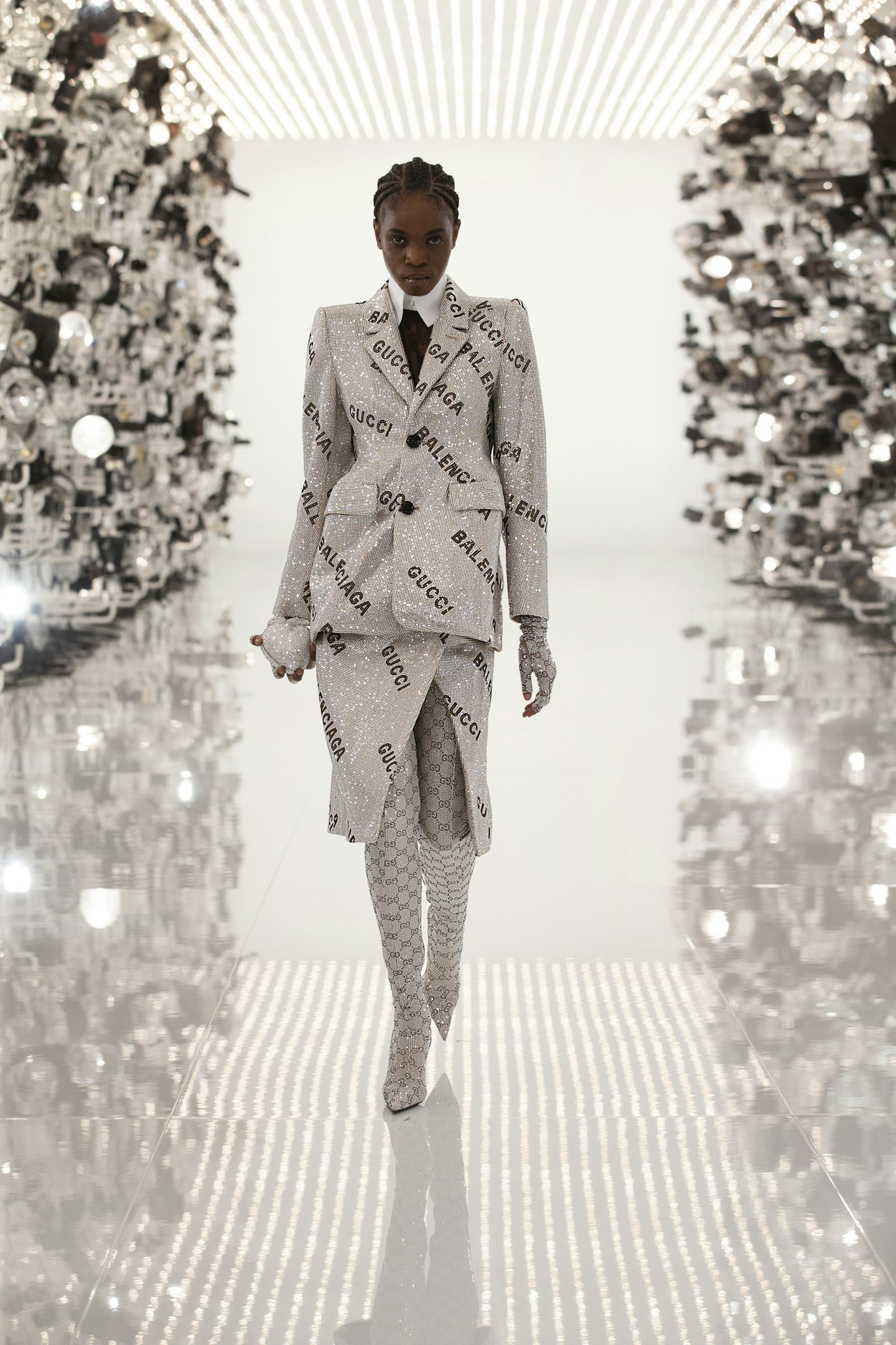 A model wearing a spangled silver skirt suit at Gucci 