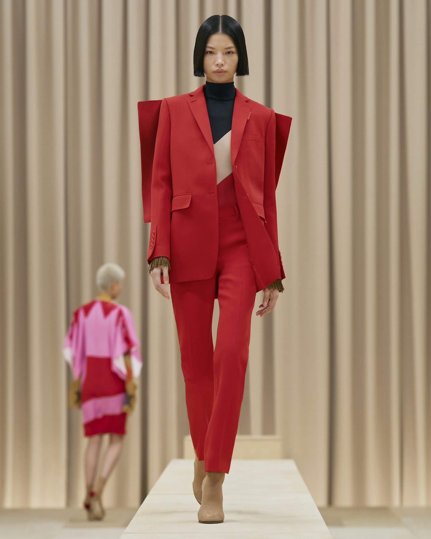 A model wearing a tomato red suit at Burberry AW21