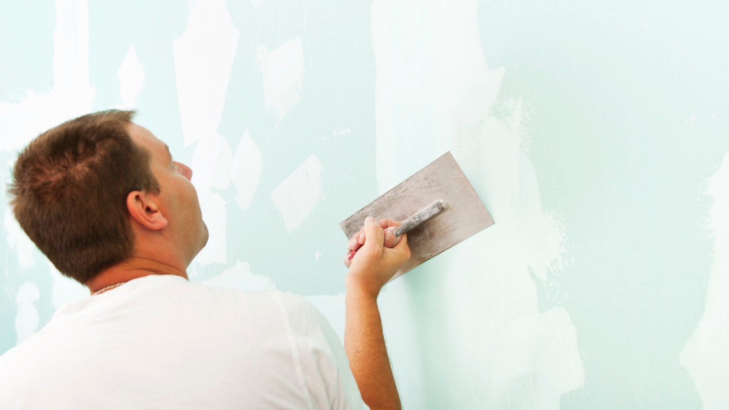 Man plastering a wall with a plastering trowel