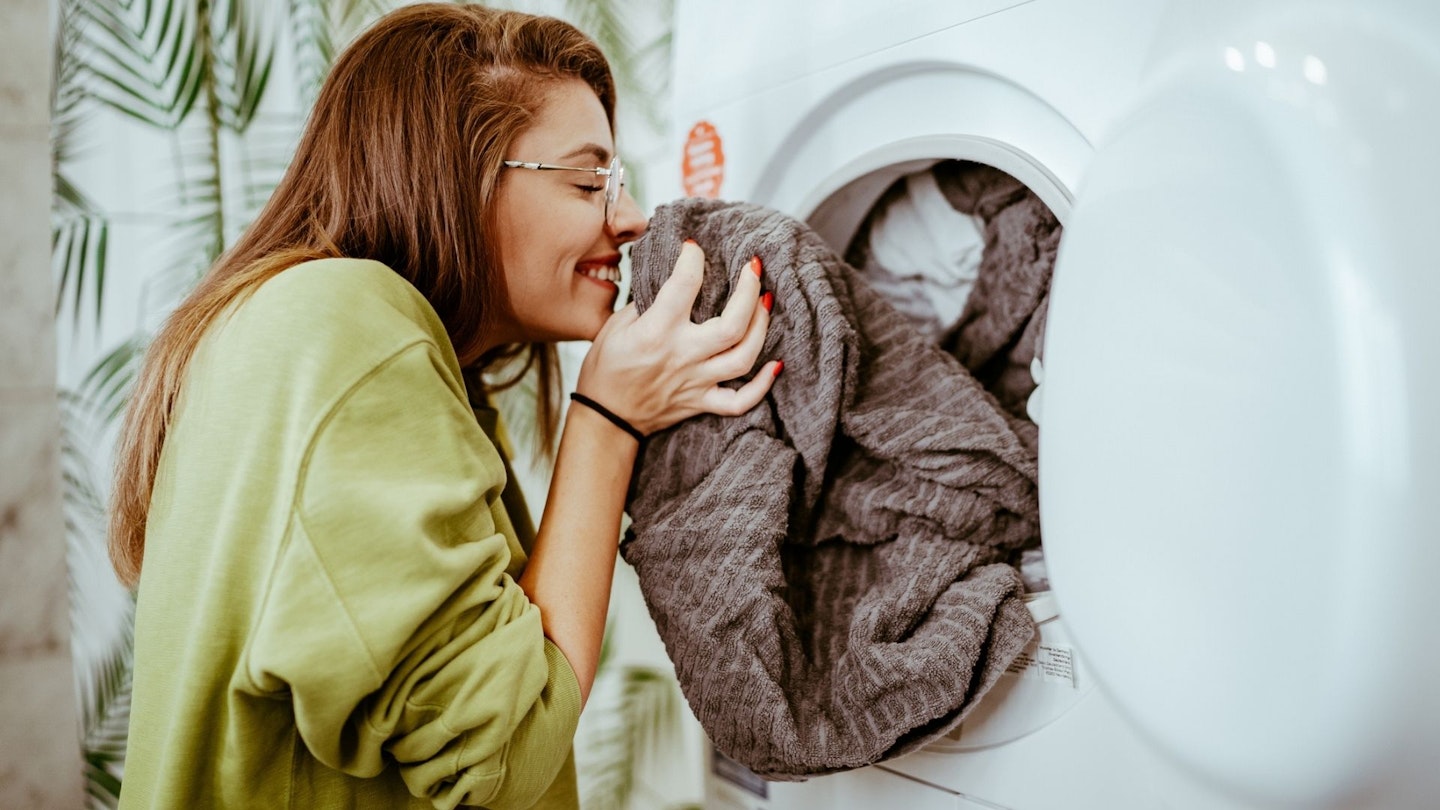 Young woman doing her laundry at home 