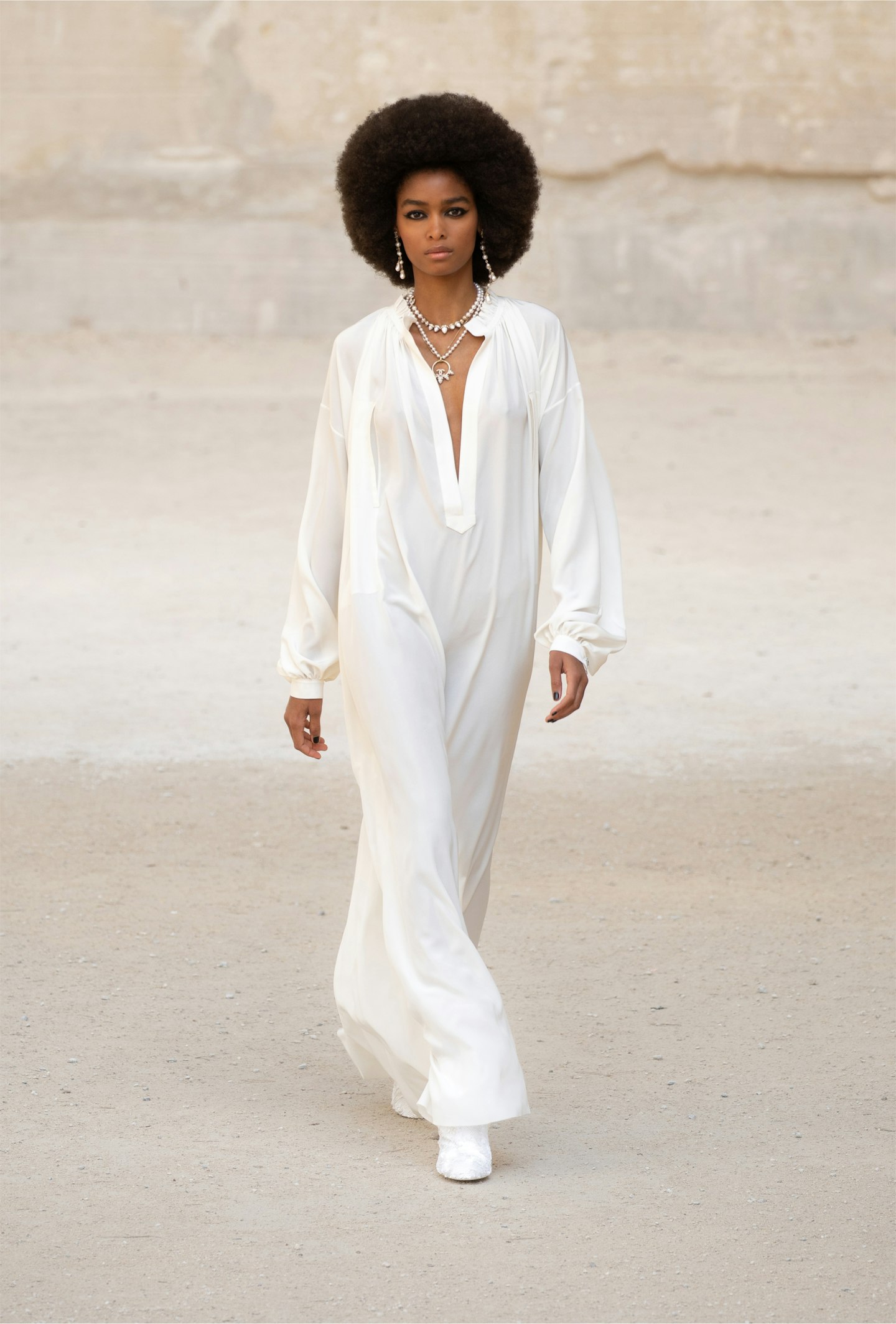 A model wearing a cream kaftan dress at Chanel Cruise 2021/22