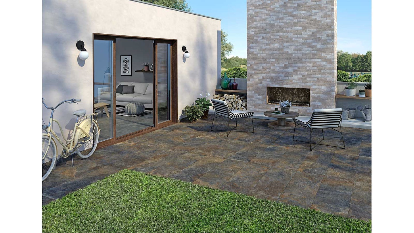 porcelain plank pavers outside bifold doors in a garden with bistro set and bike