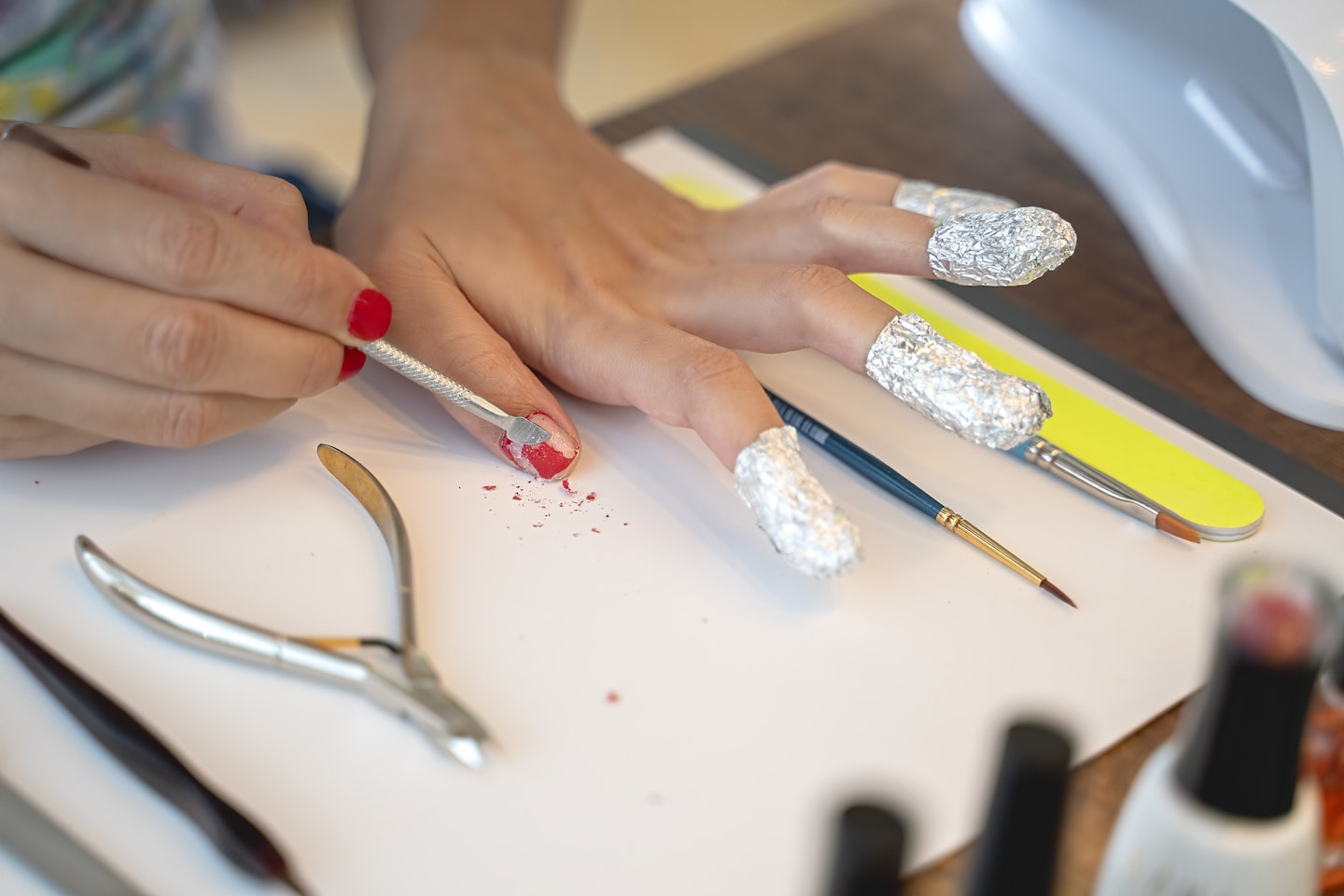 Woman removing gel nails wrapped in foil