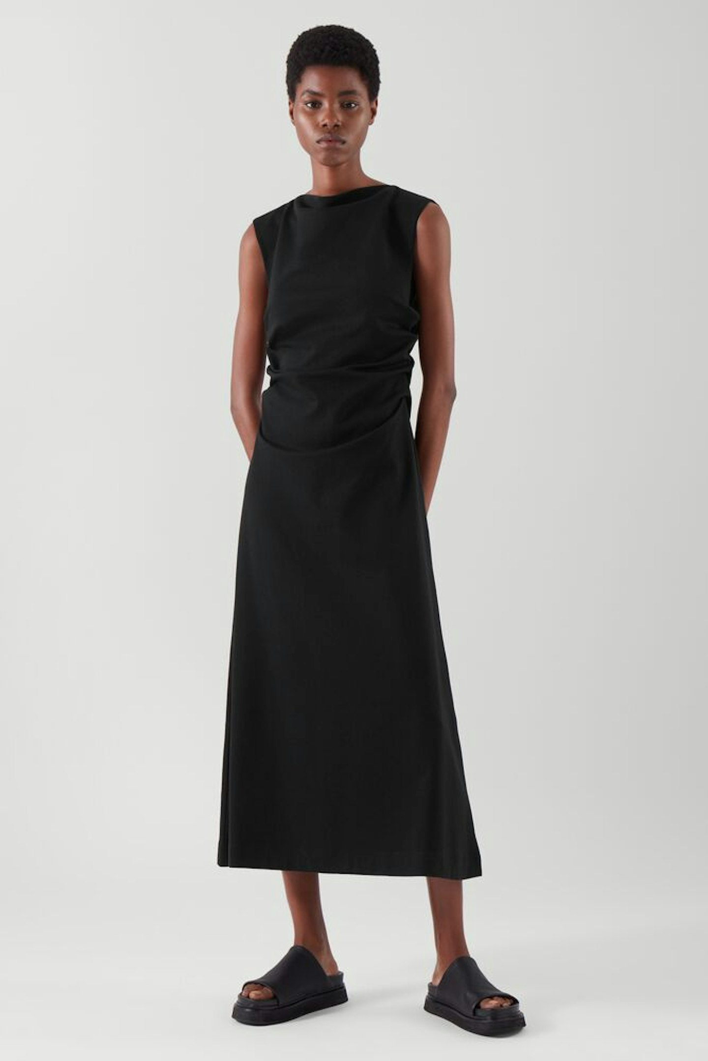 A model wearing a black dress from COS