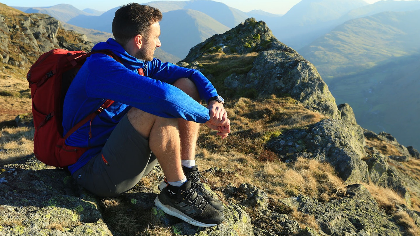 Editor Oli Reed on a hilltop wearing lightweight walking boots