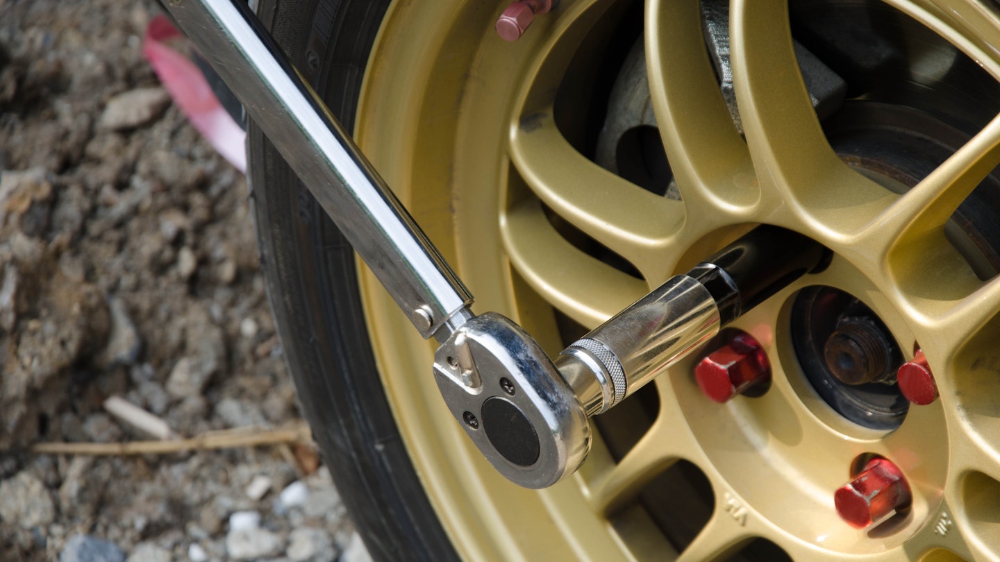 A torque wheel being used on a car's wheel nut