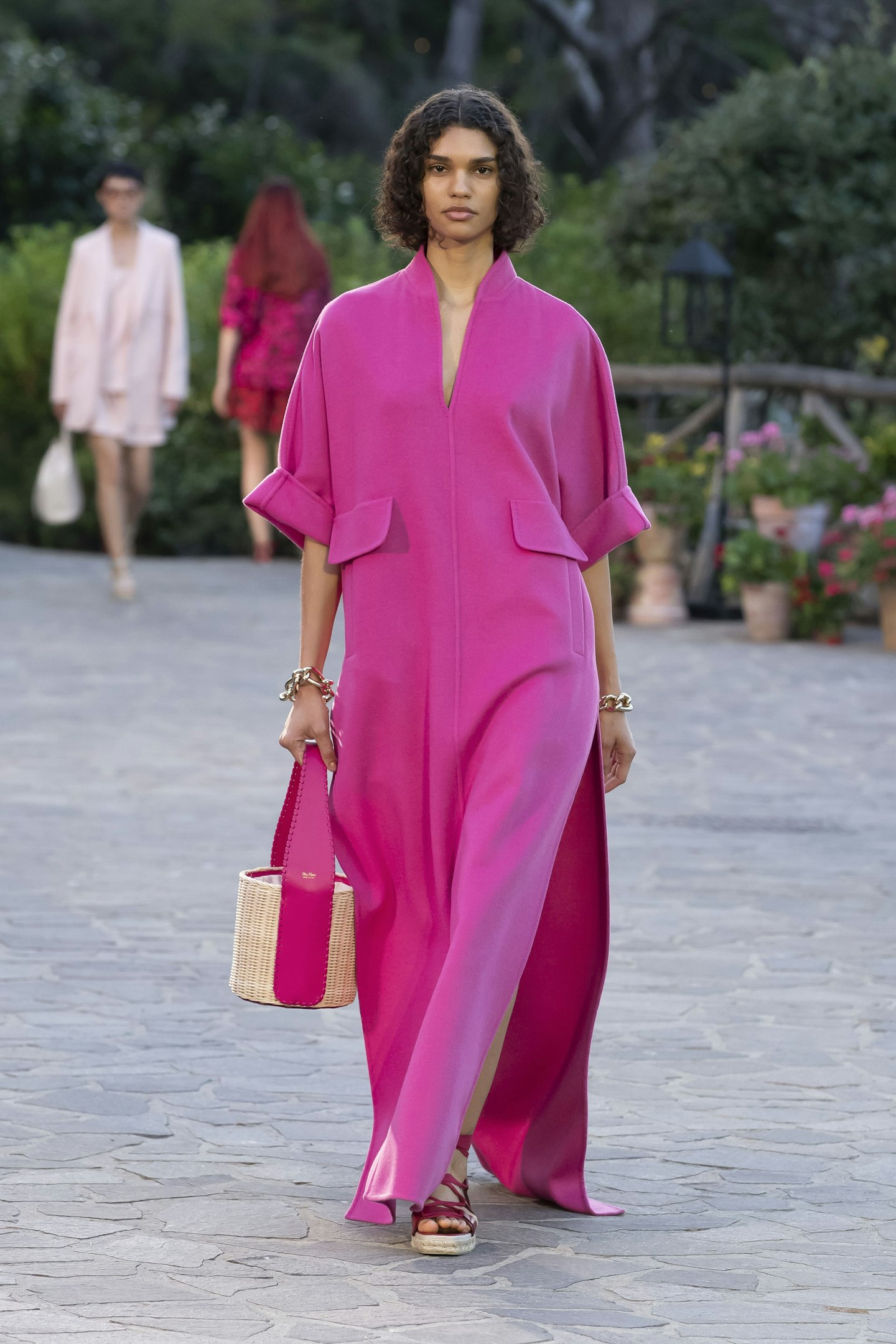 A model wearing a hot pink kaftan from Max Mara Resort 2022