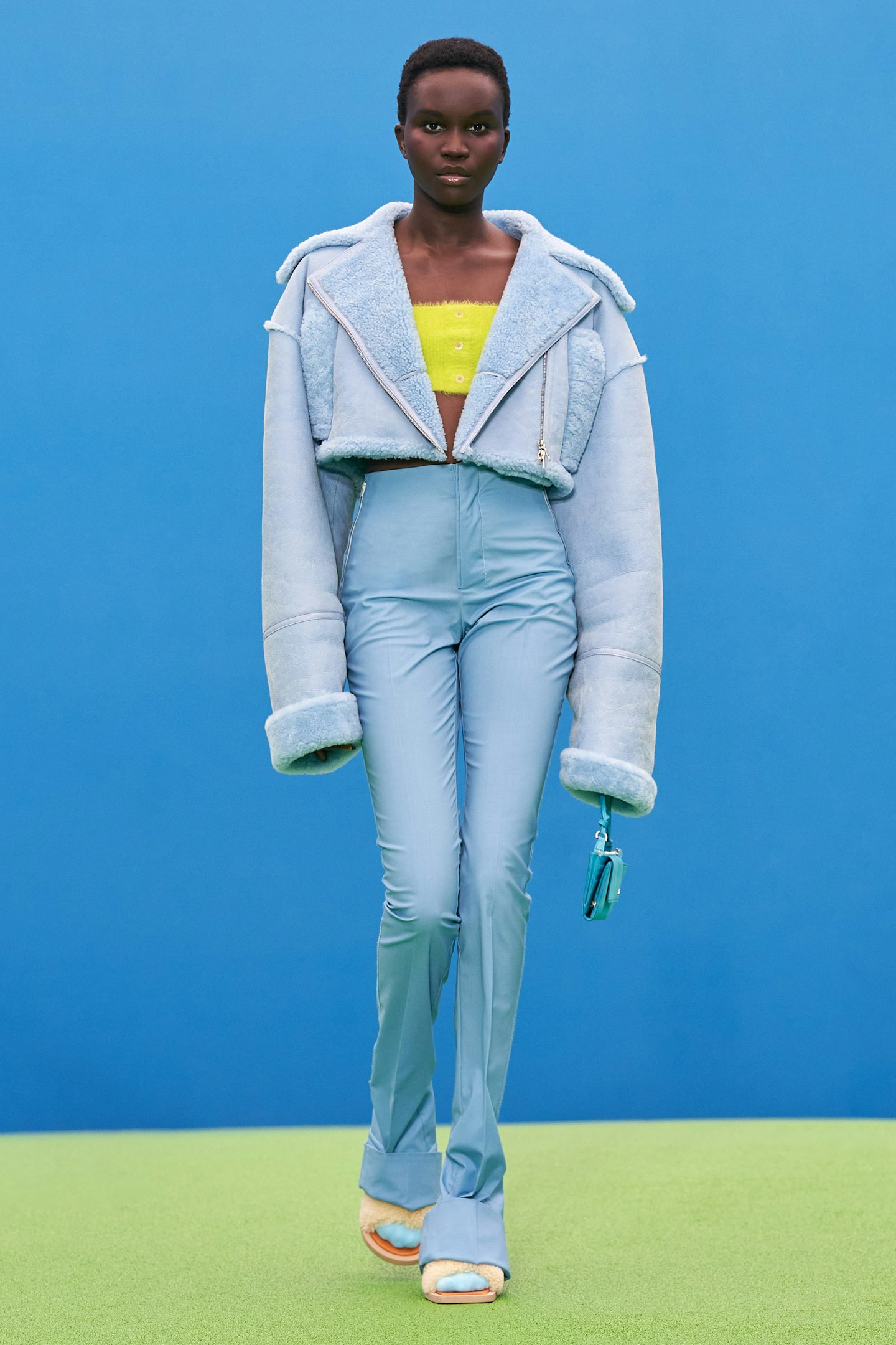 A model wearing a baby blue jacket and trousers at Jacquemus 