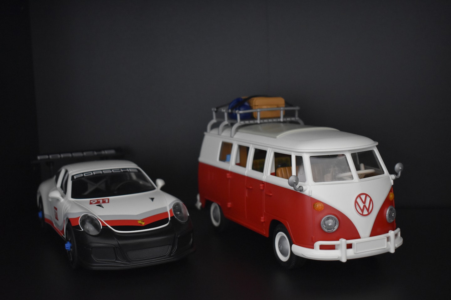 A Playmobile VW and Porsche on a shelf 