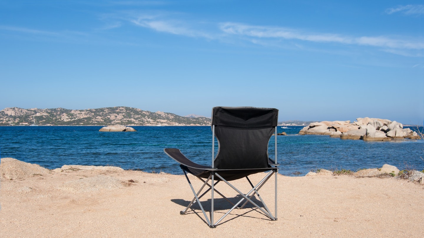 an empty camping chair overlooking the sea