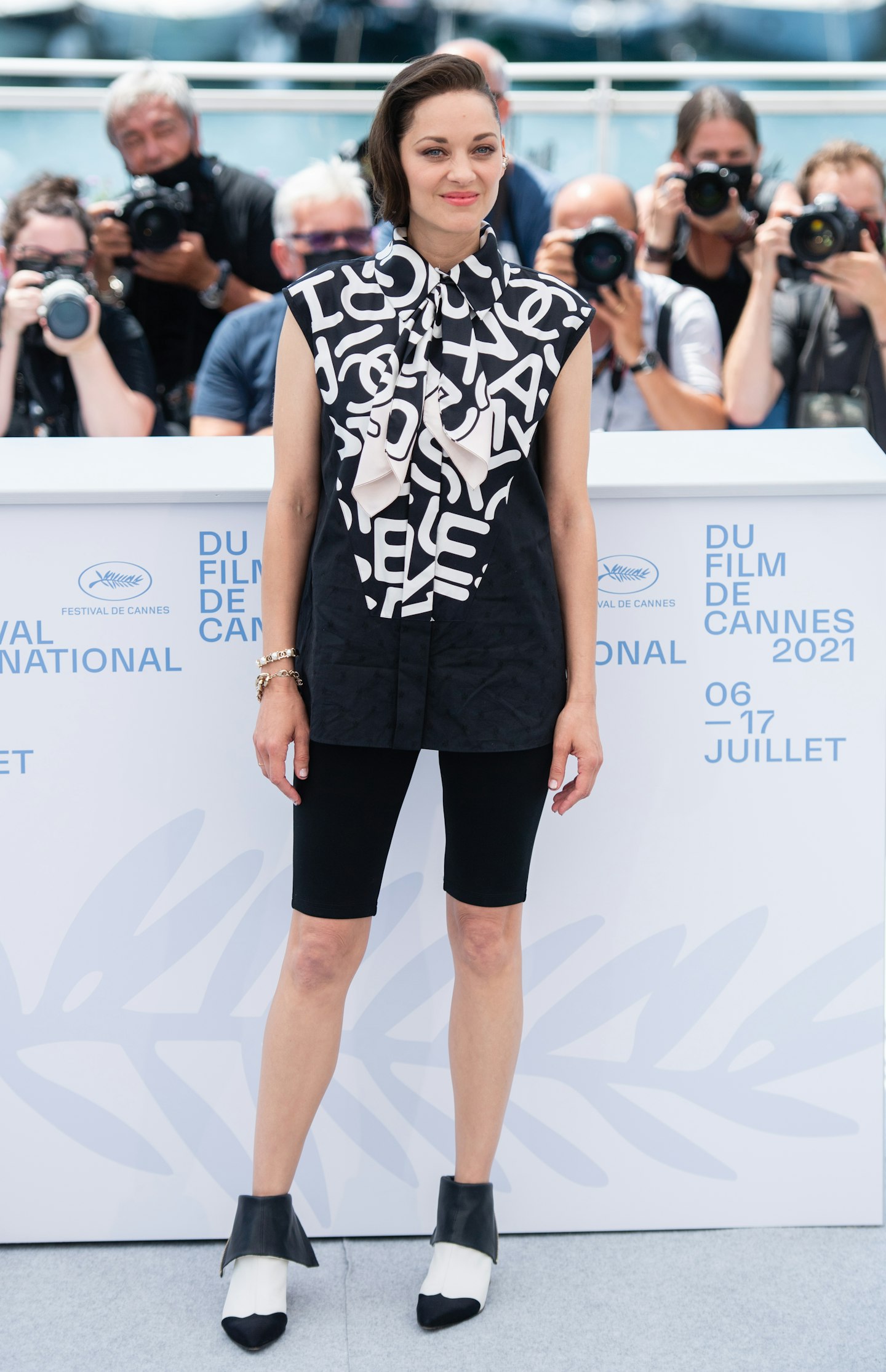 Marion Cotillard wore a full Chanel look for a photocall, consisting of cycling shorts and a printed blouse