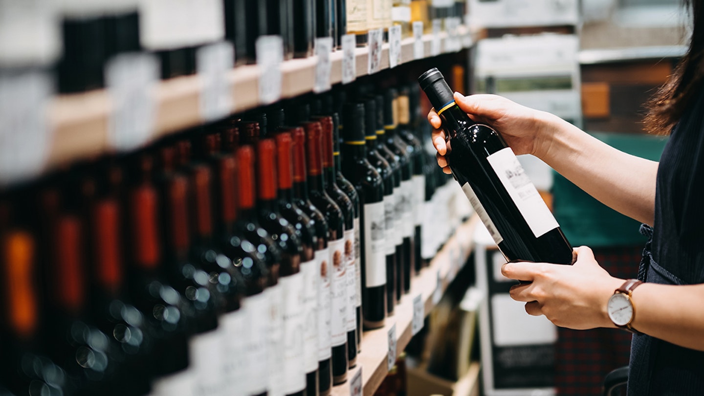 woman choosing wine in a supermarket