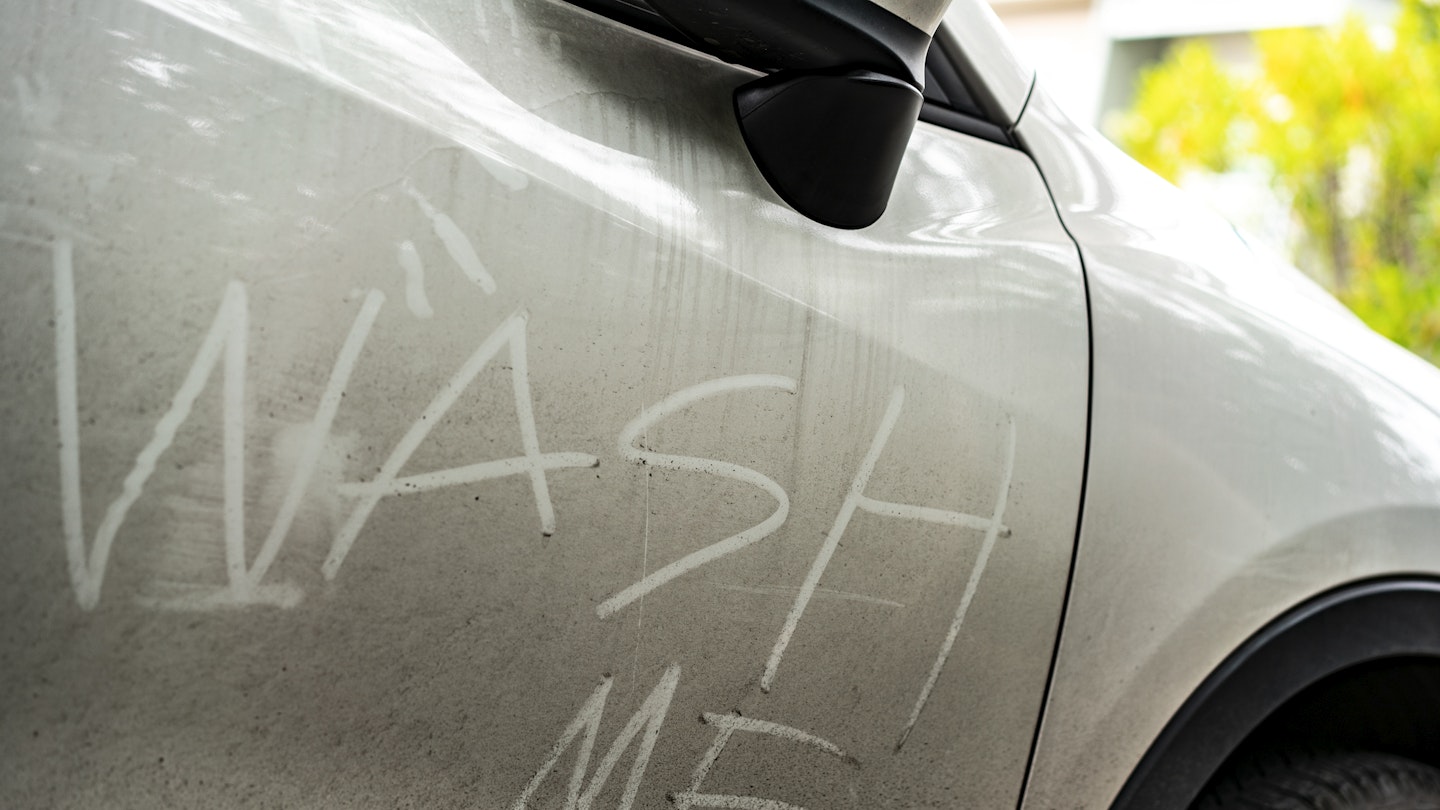 A dirty car with 'wash me' inscribed into the dirt