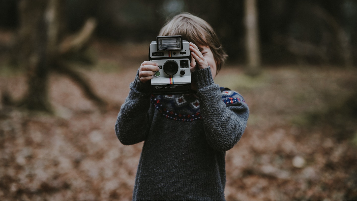 A child holding a vintage camera