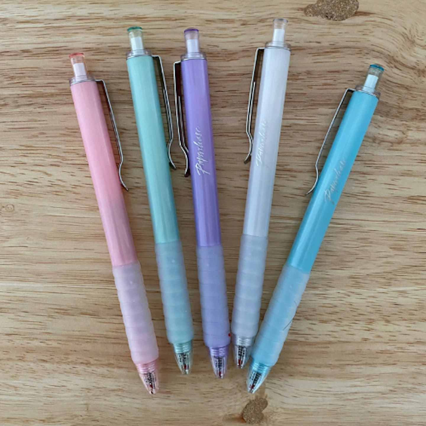 Multi-coloured pastel pens on a wooden background
