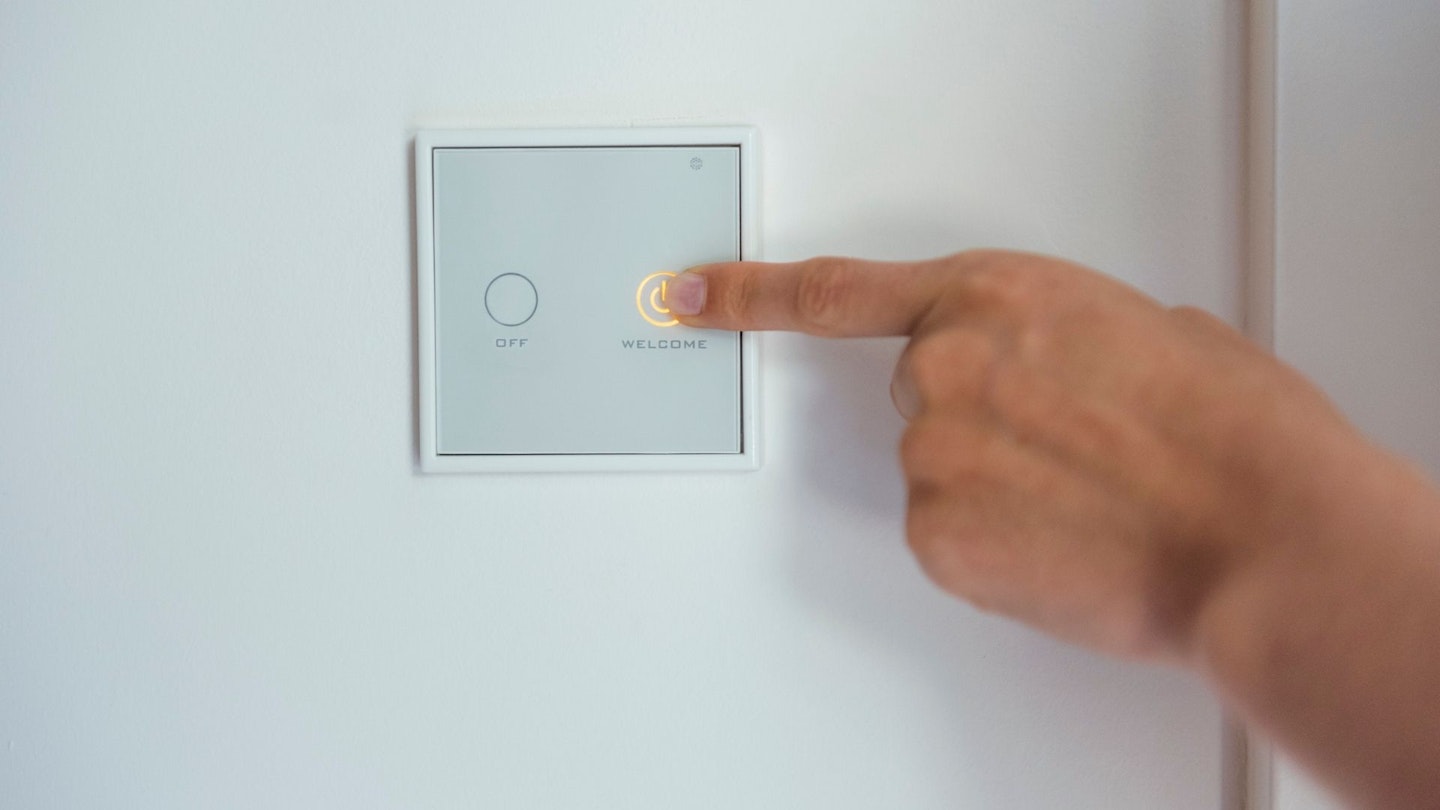 Woman pressing smart light switch