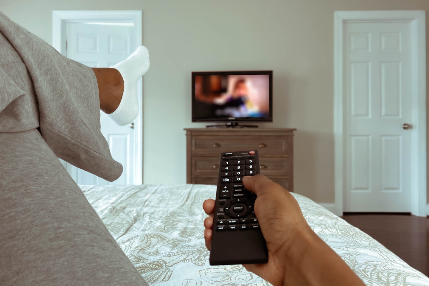 A woman watching TV from a bed