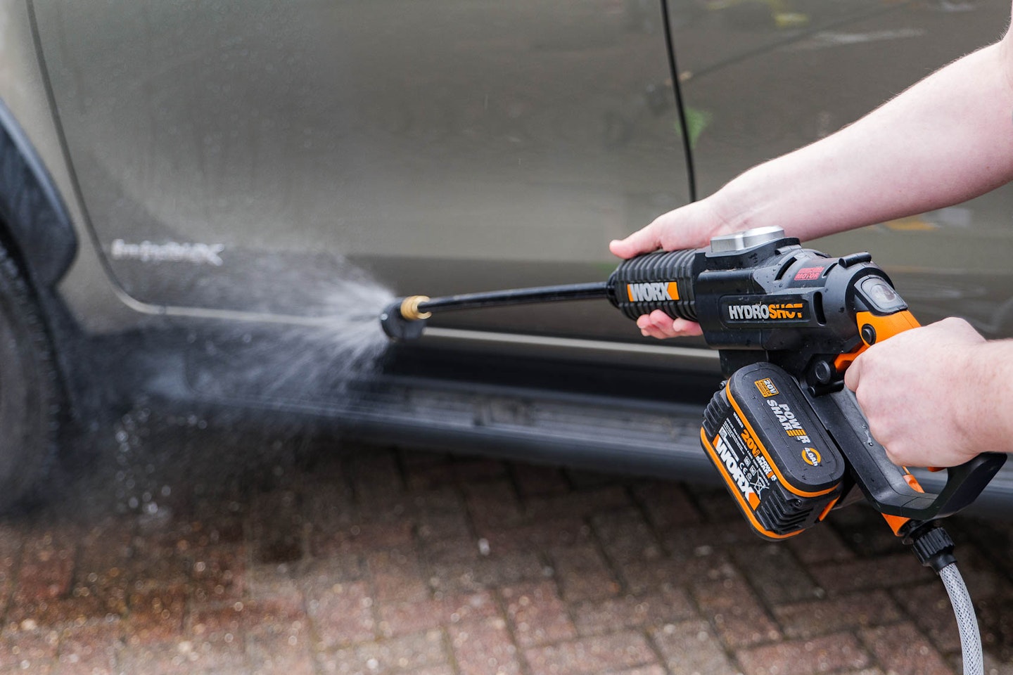The Worx power washer in action cleaning a wheel