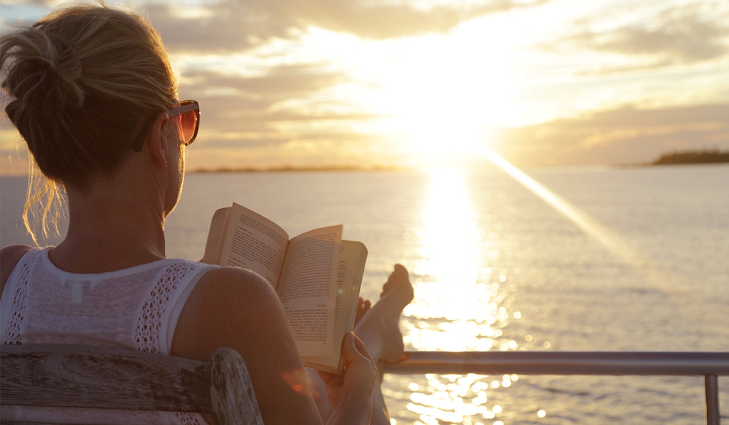 woman enjoying reading a book on a summer holiday