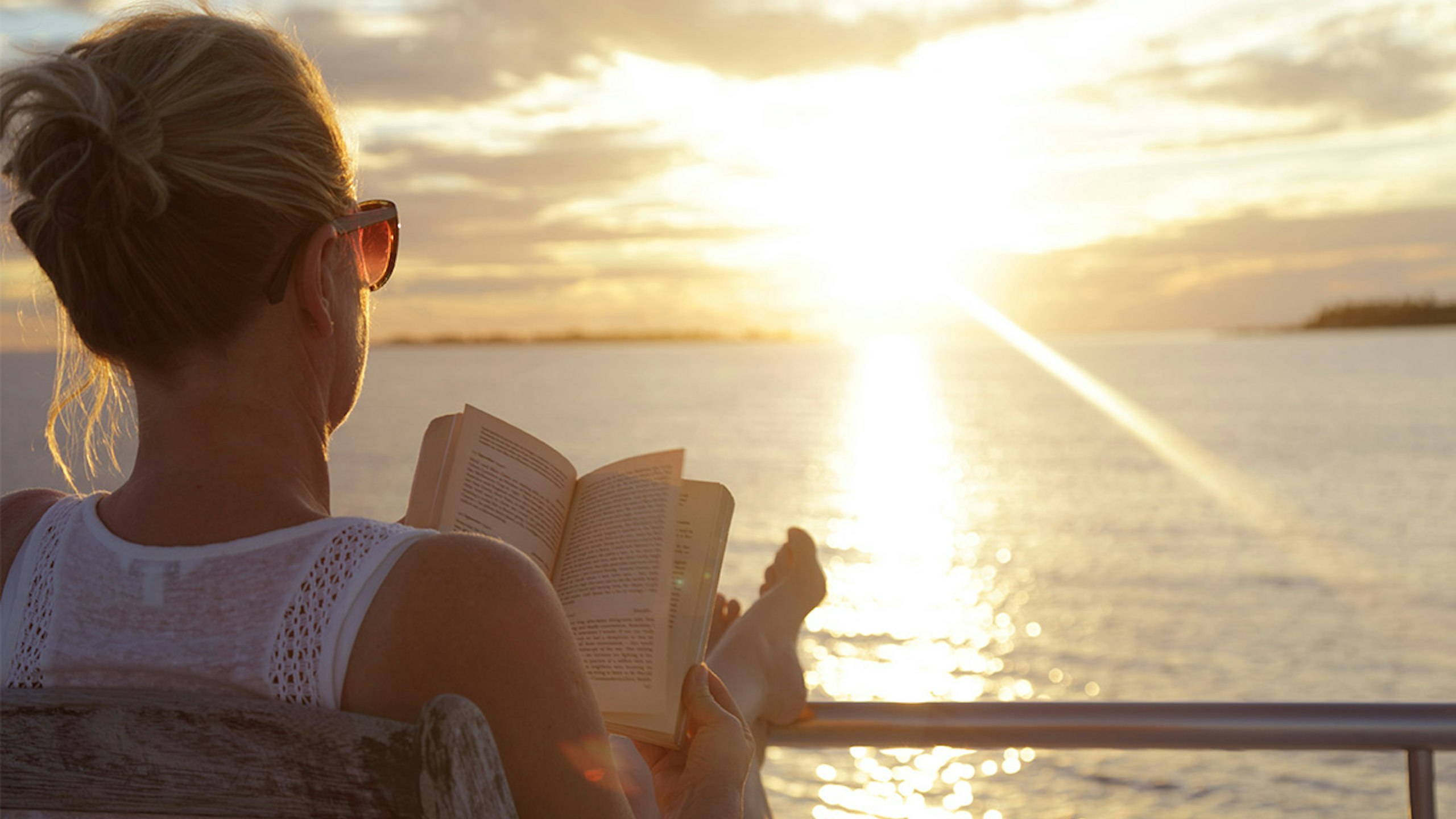 woman enjoying reading a book on a summer holiday