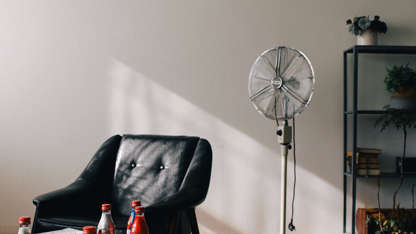 A picture of a fan next to a chair