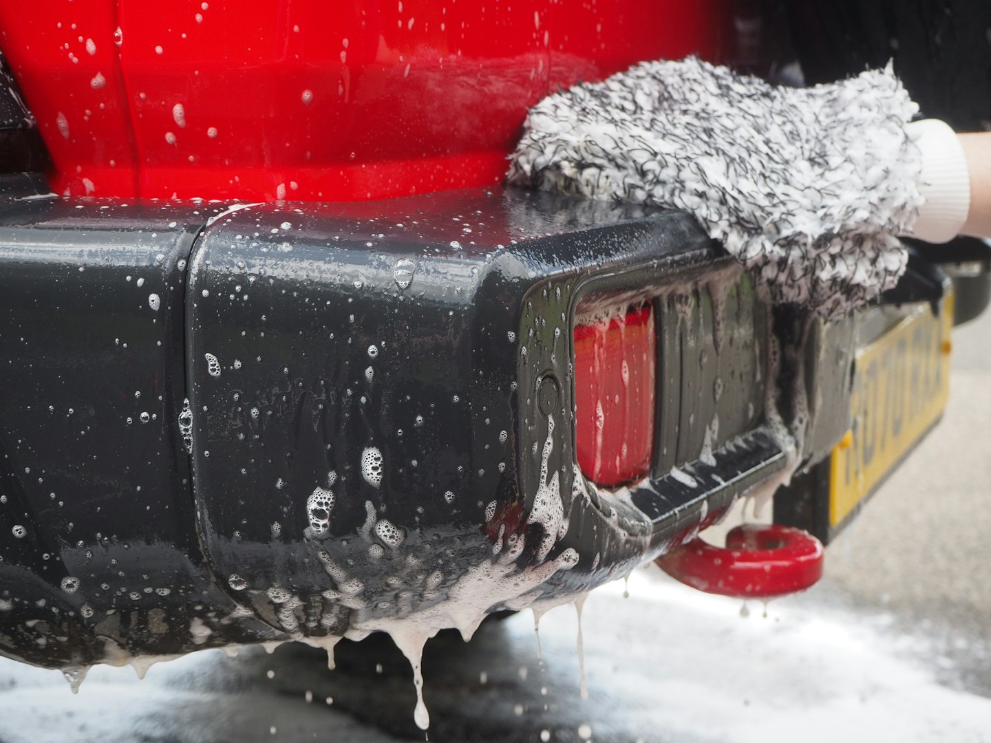 A wash mitt in use on a Jeep Wrangler