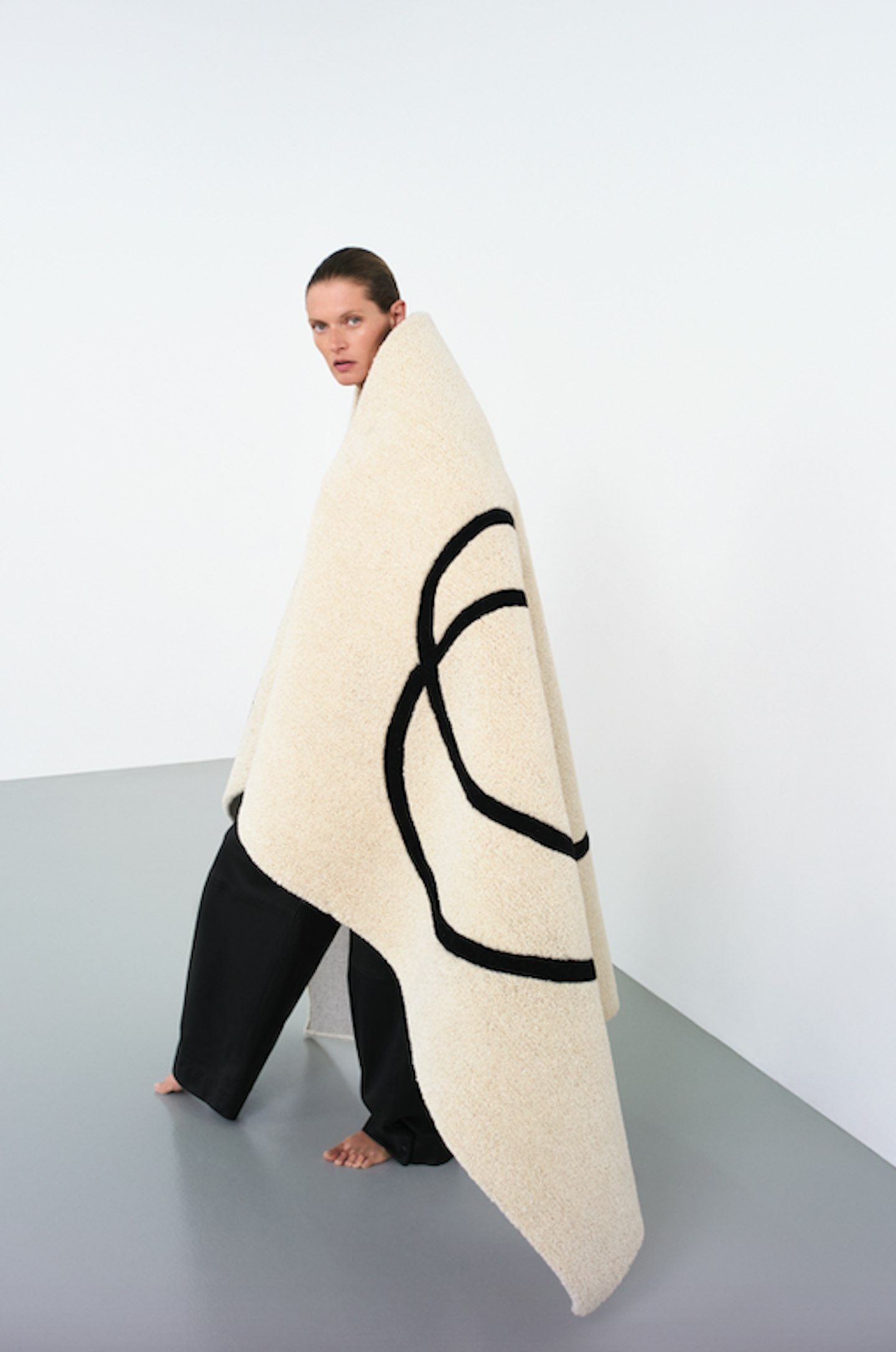 A model wearing a cream rug from KASSL Editions x Zara
