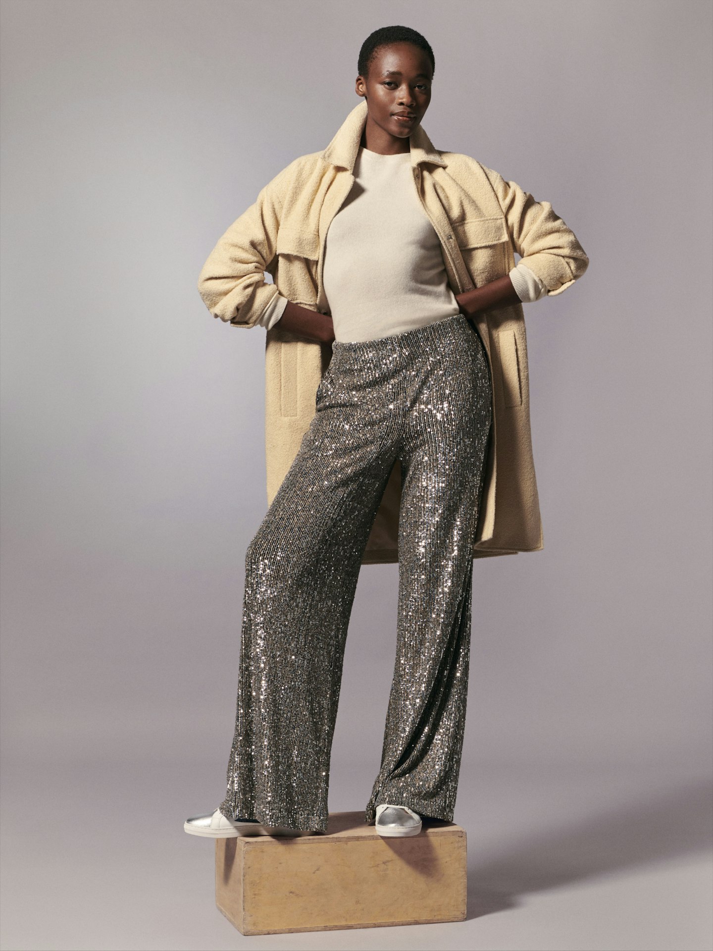 A model wearing sequinned trousers and a trench coat