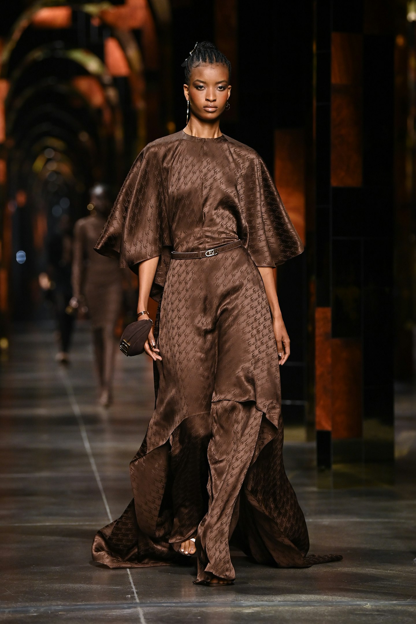 A model on the catwalk wearing a chocolate brown dress at Fendi