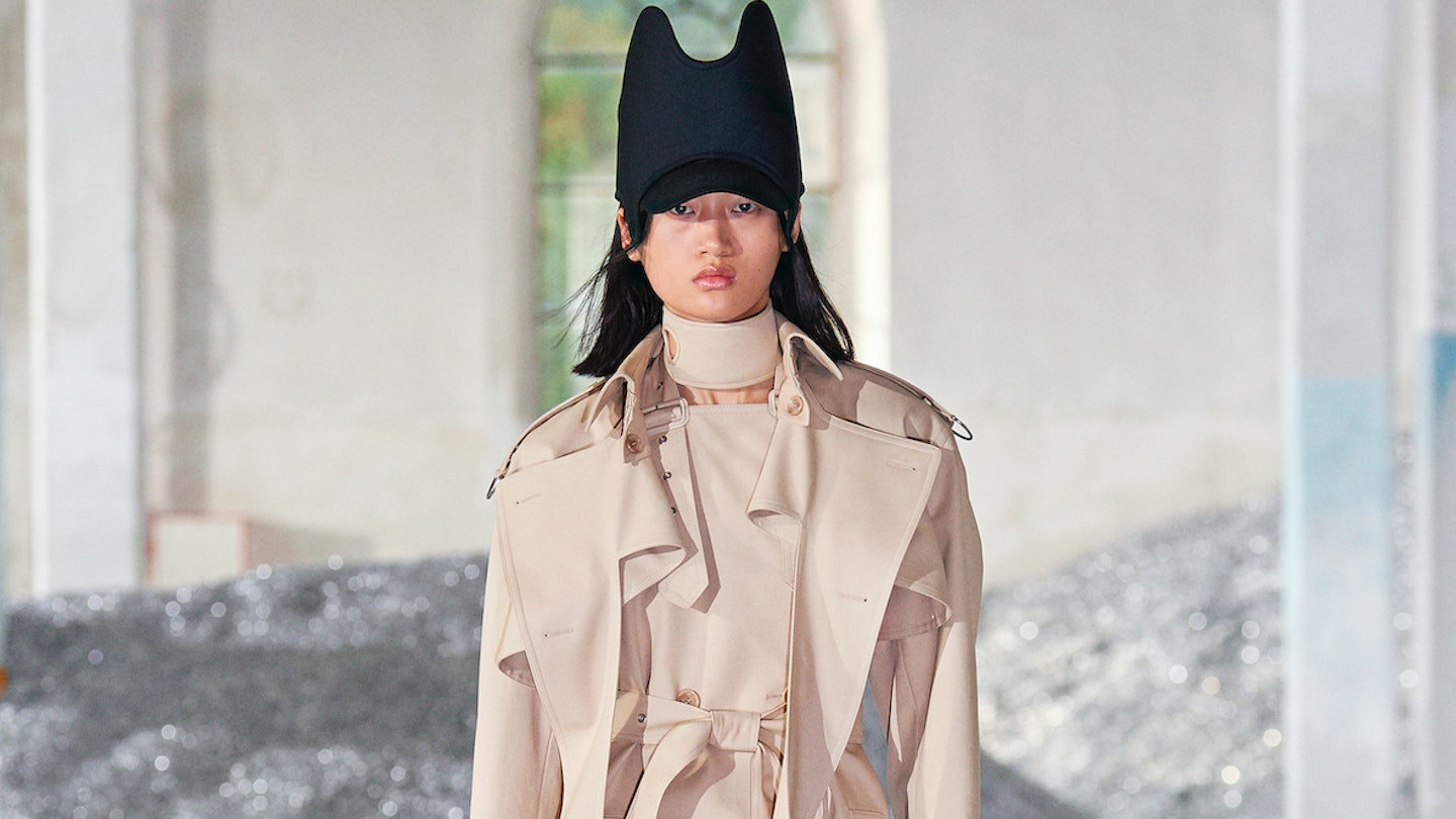 A model wearing a trench coat and black hat at Burberry