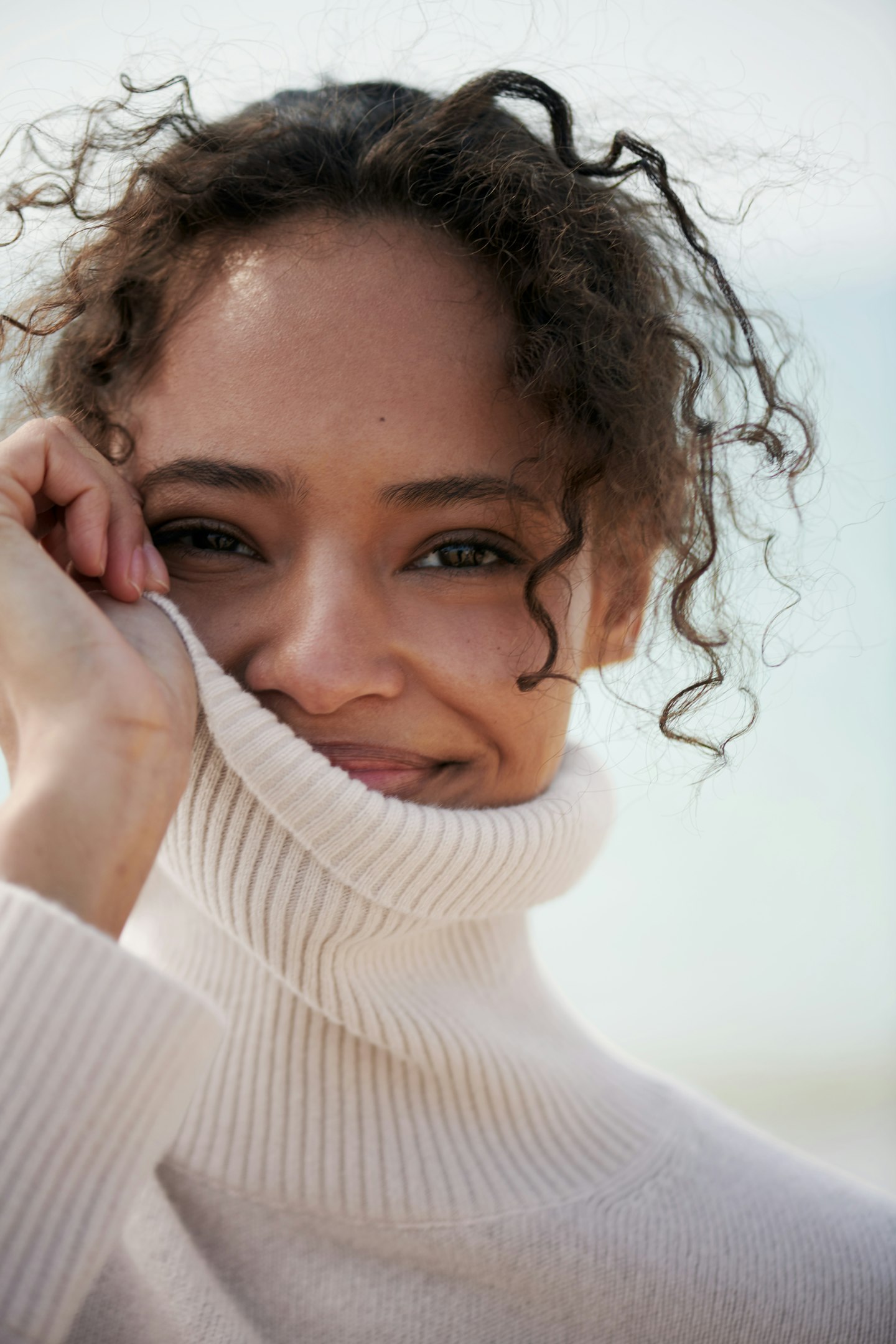 A model wearing a cream roll neck from The White Company