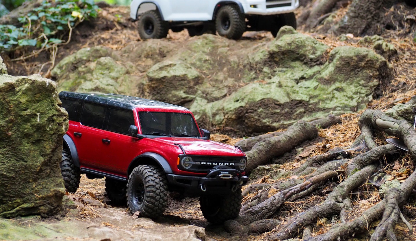 Traxxas Bronco driving on rocks and tree roots