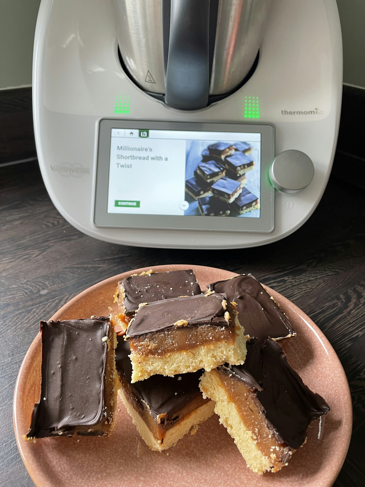 A plate of homemade caramel shortbread in front of the Thermomix