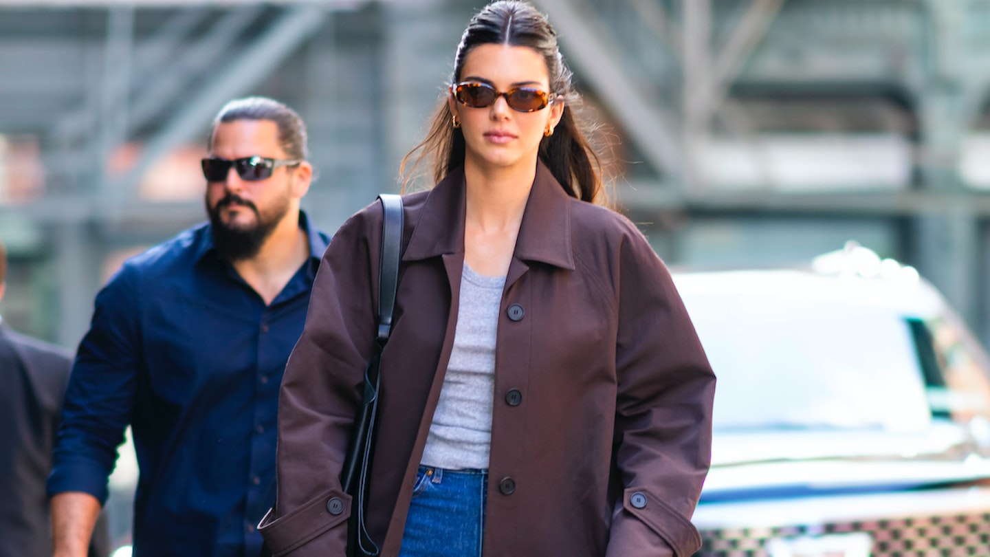 Kendall Jenner wearing a brown overcoat and blue jeans 
