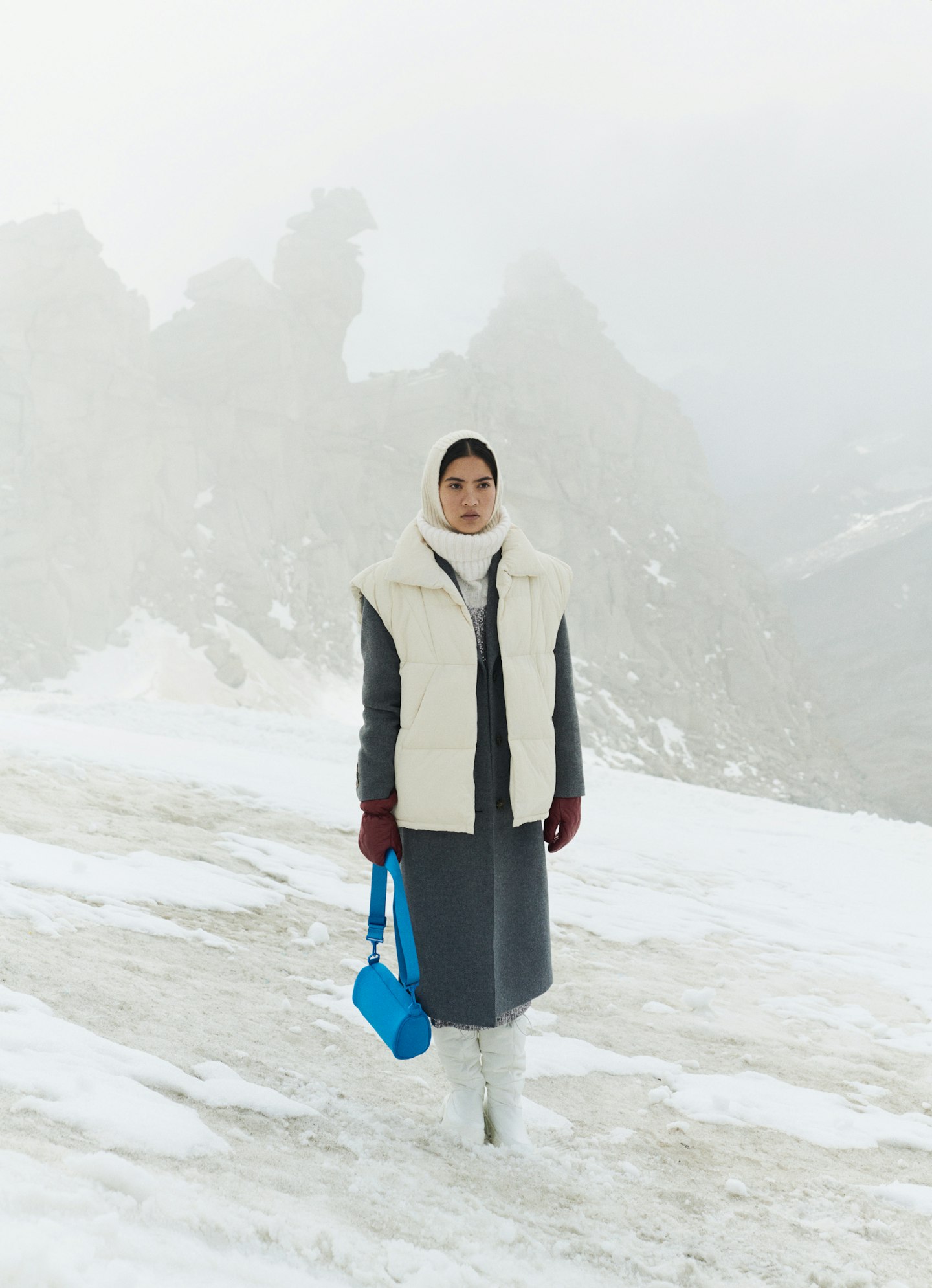 A model wearing a grey coat and cream gilet from Reserved