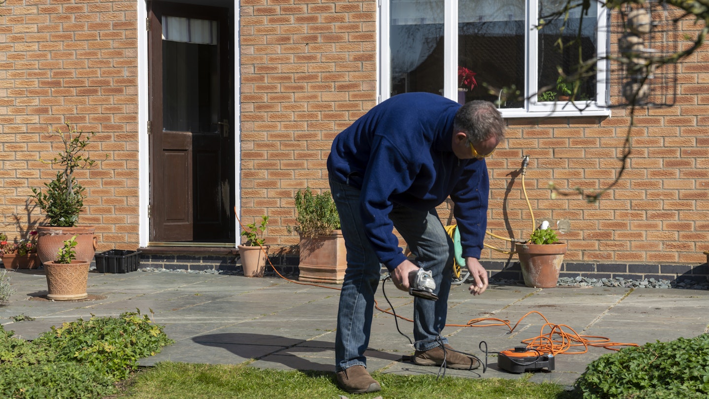 A person using an extension cord for an angle grinder