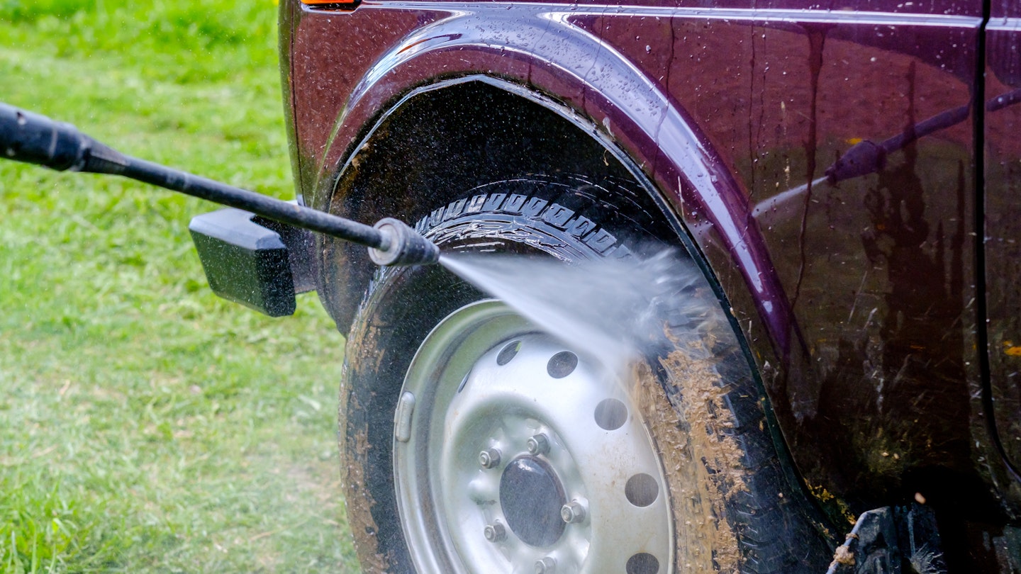 Cleaning the mud off a tyre with a pressure washer