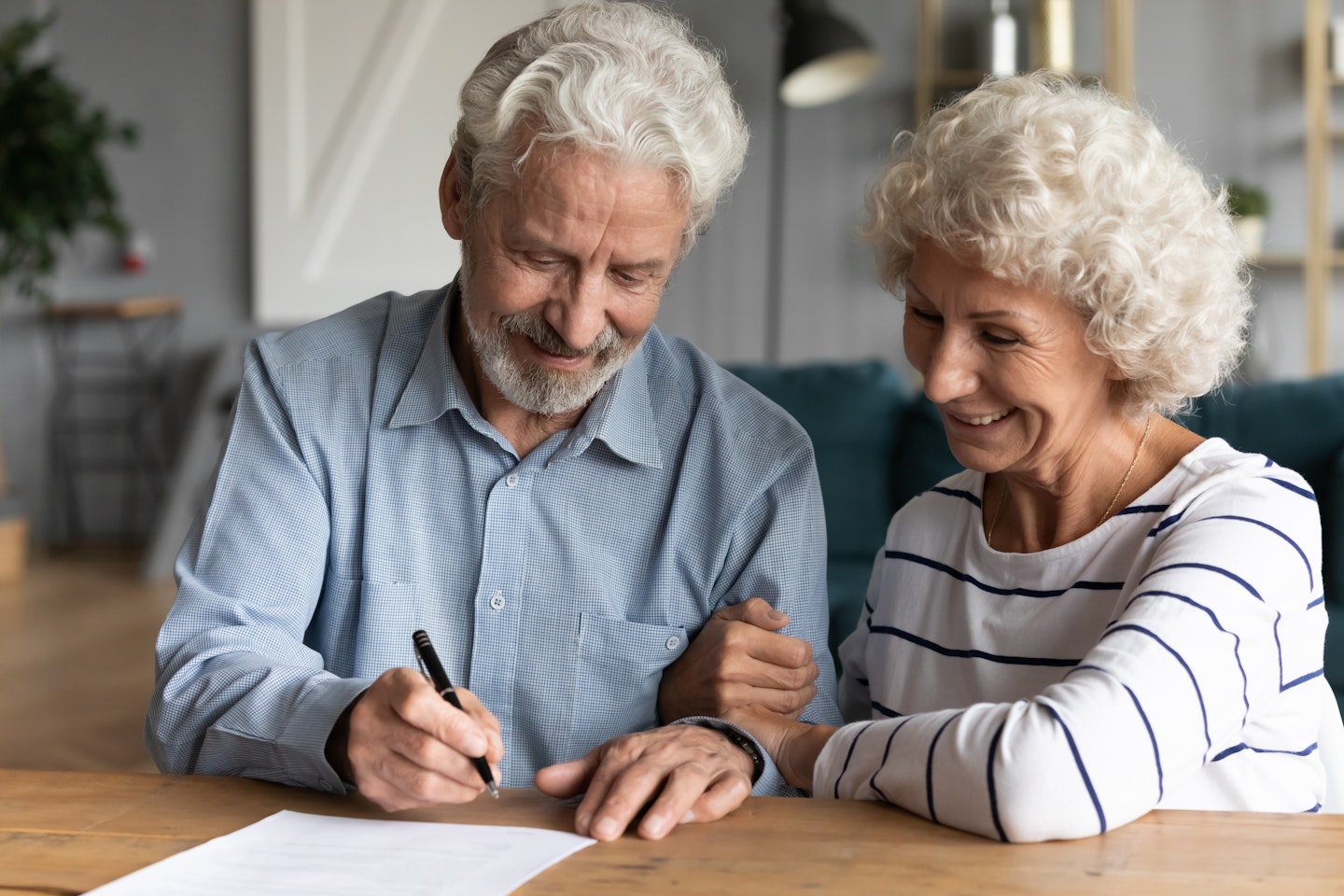 Elderly couple signing papers