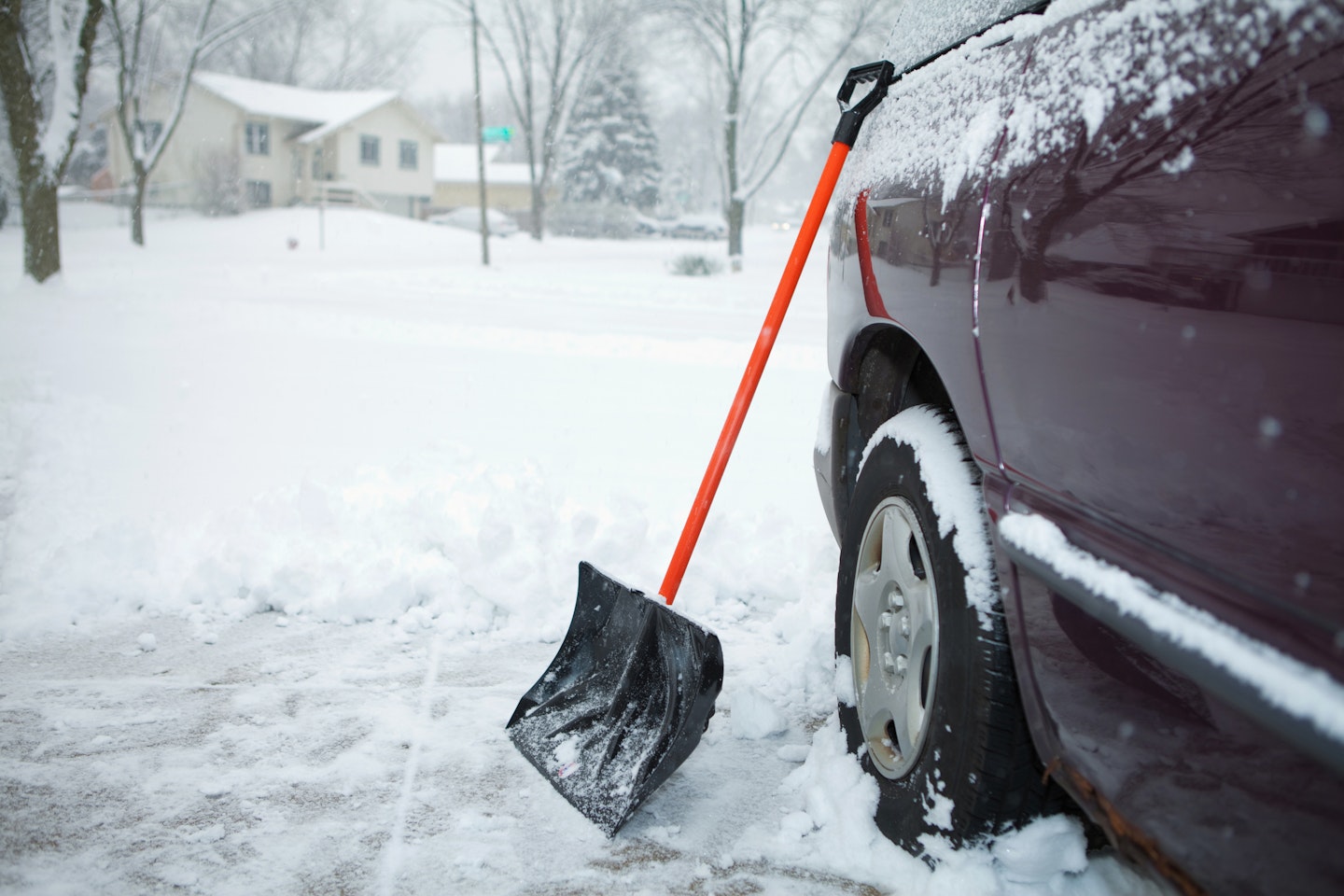 A snow shovel next to a car
