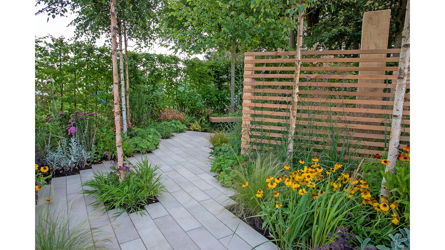 pale porcelain paving with orange flowers and slatted fence