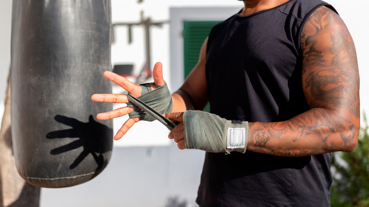 Man wrapping hands for punch bag