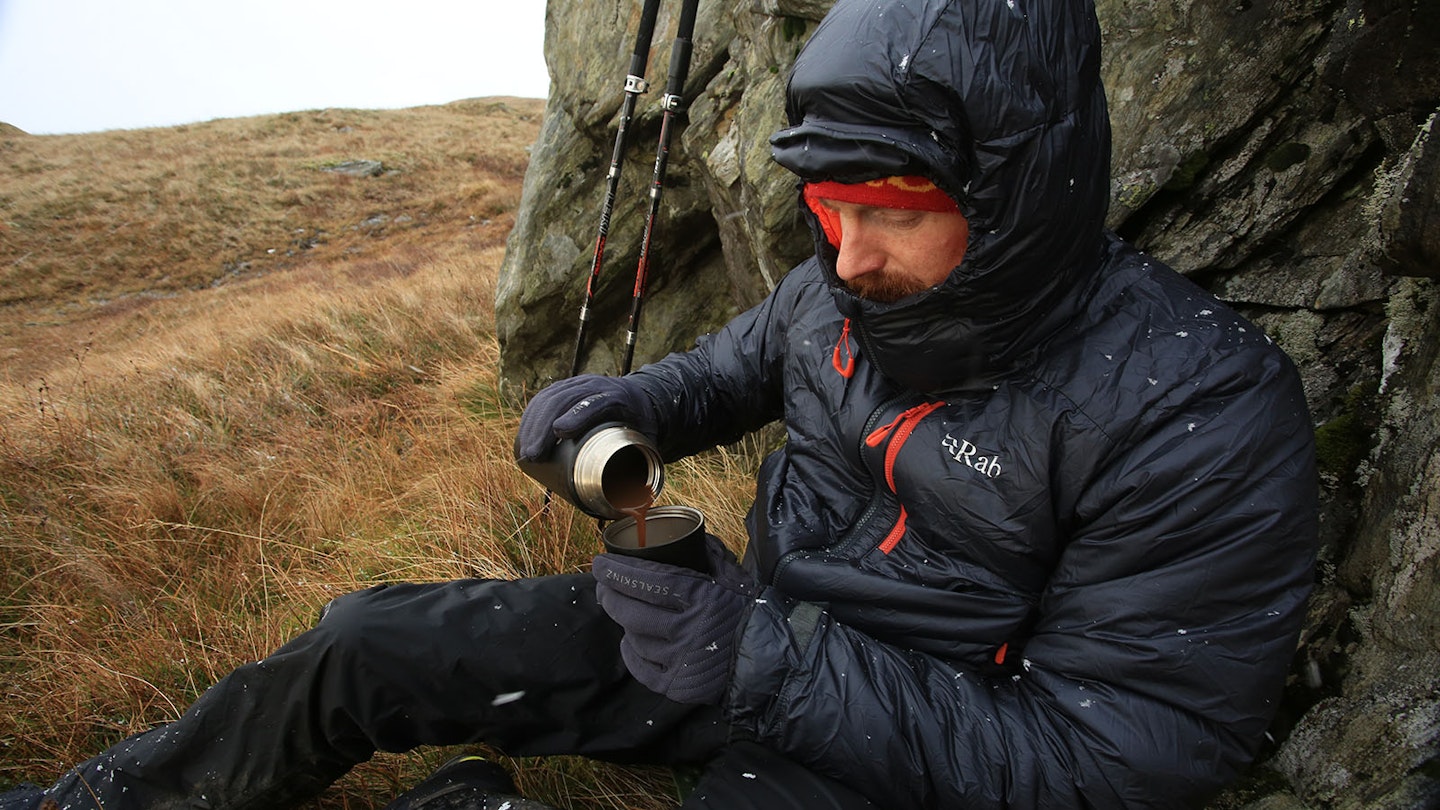 Pouring coffee while wearing a Rab winter insulated jacket