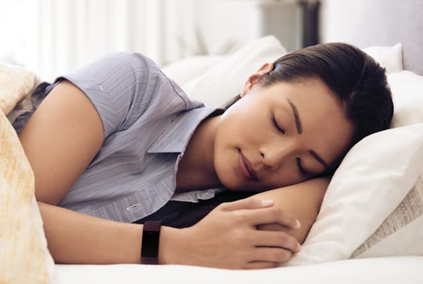 Woman asleep wearing Fitbit Charge 4