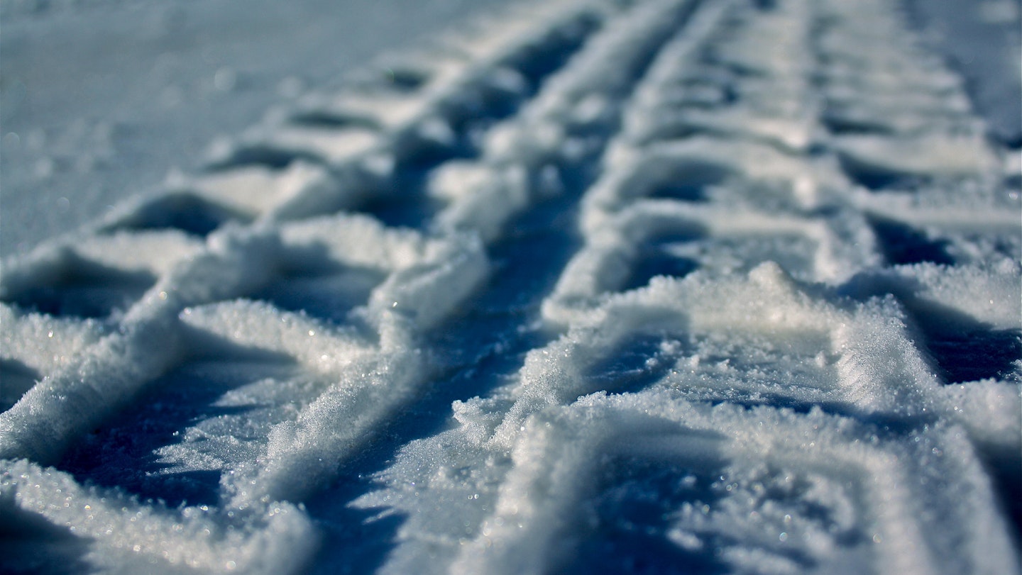 Closeup of car tyre mark in snow