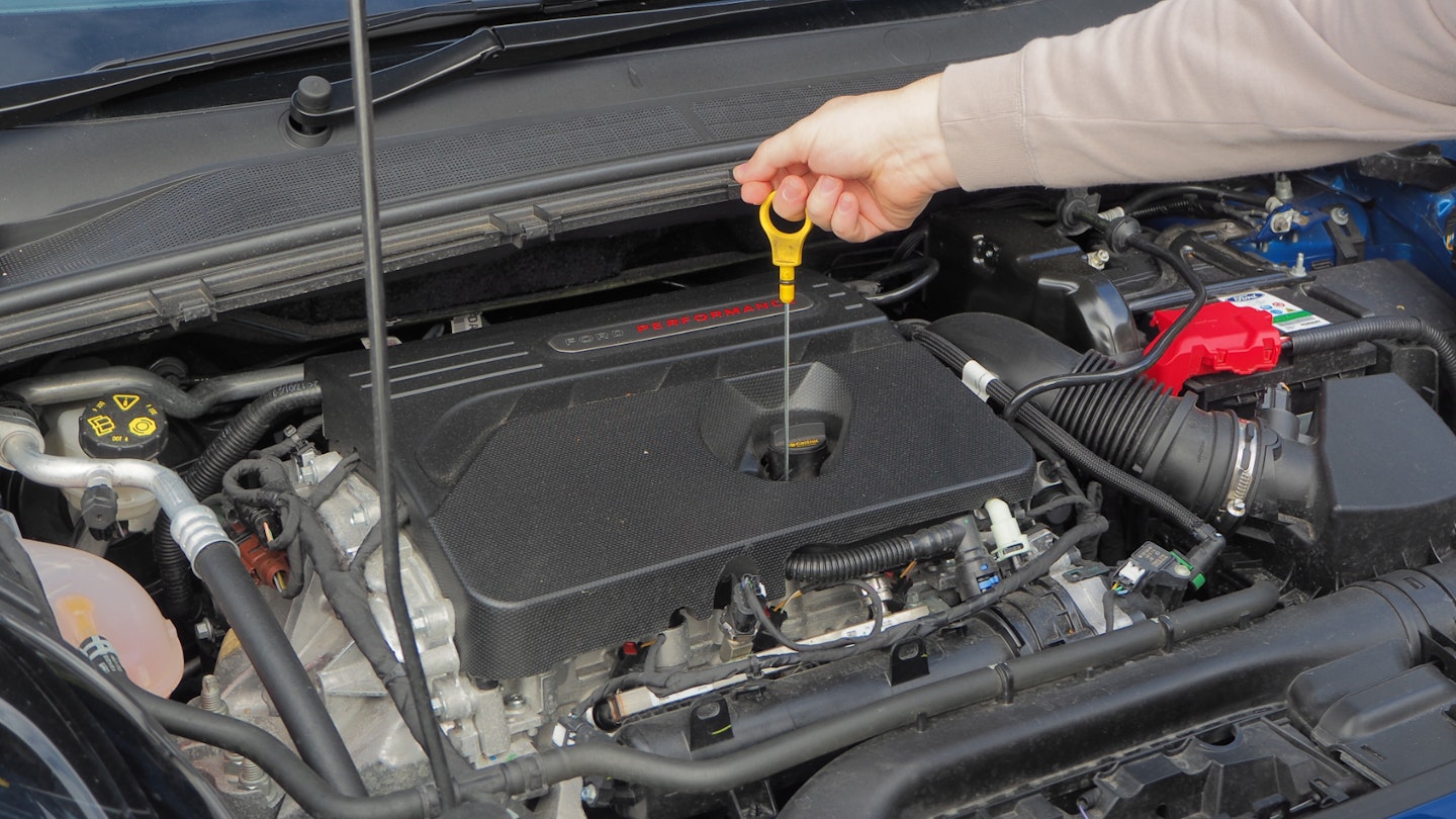 Checking oil dipstick 