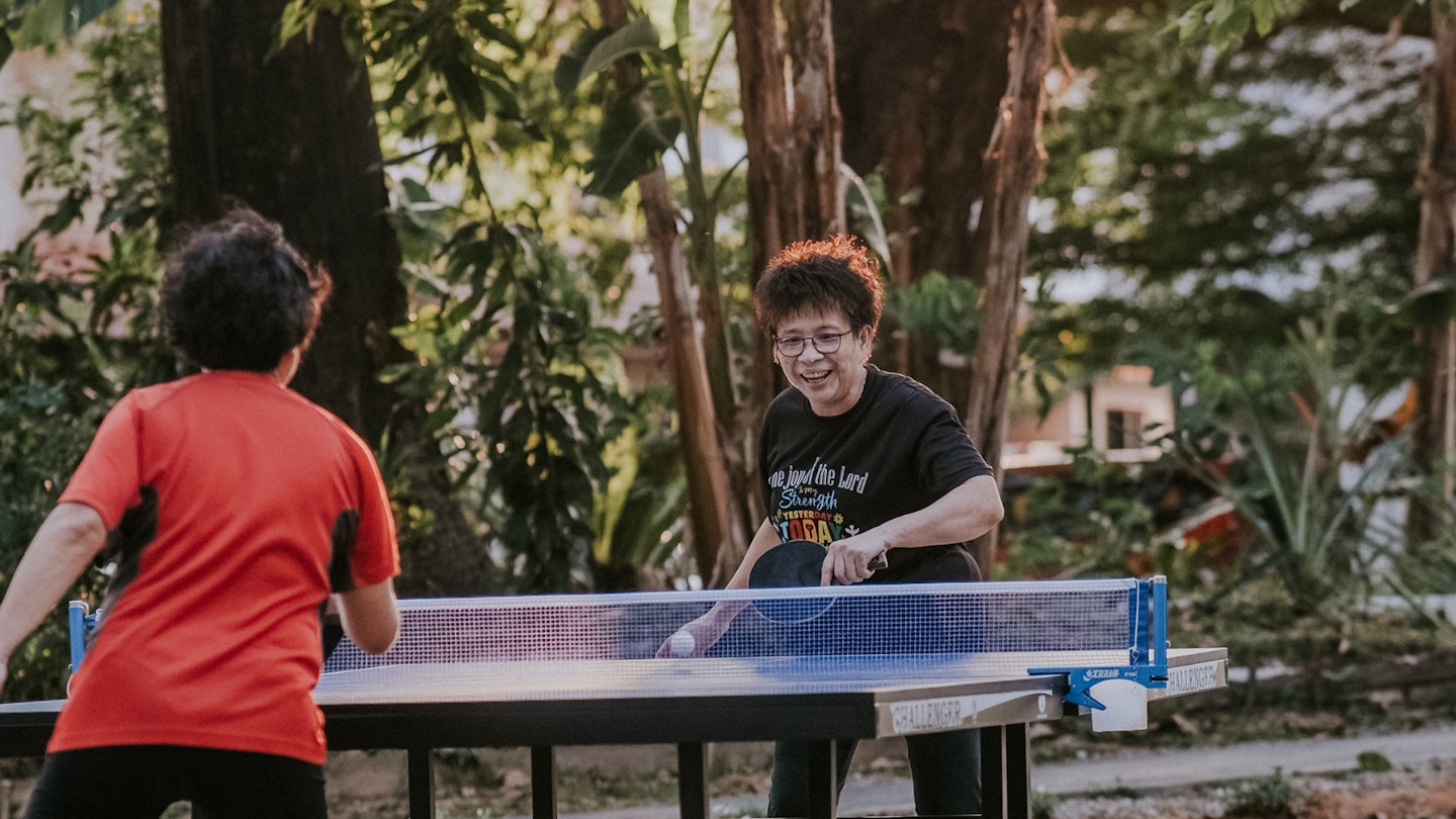 A picture of two women playing table tennis