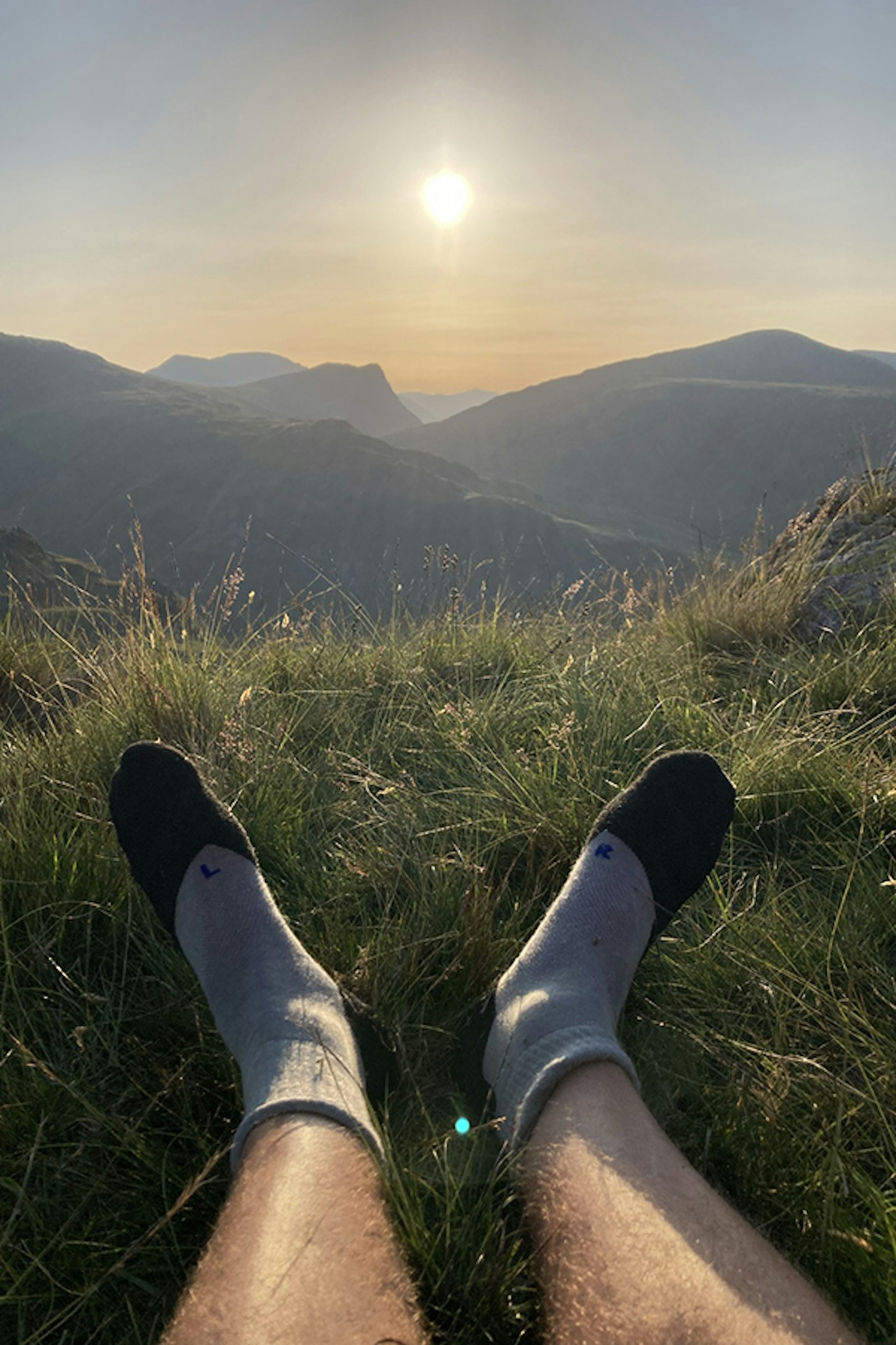 socks on feet on grass in the sunshine in the evening on a mountain